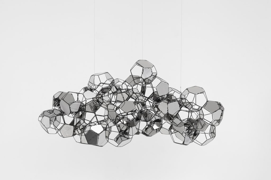 El trabajo de Saraceno se despliega en el cruce entre arte, arquitectura, ciencia, técnología y activismo. Sus propuestas buscan aportar conocimientos y experiencias colectivas para enfrentar algunas de las problemáticas más urgentes del presente. Sus proyectos llaman la atención sobre la necesidad de renovar estilos de vida e indagan sobre formas alternativas y sustentables de transporte, comunicación y habitabilidad. En ocasiones, despliega su obra fuera de los circuitos artísticos y tiene lugar en el espacio aéreo o en paisajes, como desiertos o salares, en diálogo con las comunidades locales. Sus exhibiciones suelen acercar a museos y galería propuestas radicales que modifican los usos tradicionales del espacio, involucrando al público en experiencias corporales desafiantes y de cooperación. Las obras también integran fenómenos fuera del rango de lo visible, como las vibraciones que producen cuerpos y materiales, o tienen como parte y destinatarixs a habitantes no-humanxs del lugar, como las arañas. En ese sentido, en cada proyecto, el artista trama un sistema orgánico de relaciones entre público y entorno para abrir canales de comunicación y sociabilidad que cruzan las fronteras entre sentidos y especies. Saraceno es un observador planetario que encuentra referencias formales y estéticas en fenómenos tan amplios como los ritmos de las corrientes de aire y las redes ecosistémicas que hacen a la atmósfera y la biosfera, integrándolos en su producción de manera plástica, escultórica, instalativa y también fotográfica. Trabaja junto con un enorme equipo de colaboradorxs para desarrollar investigaciones en conjunto desde distintos saberes, especialistas e instituciones científicas. Unión de utopía y posibilidad, la práctica artística de Saraceno expande los límites del arte contemporáneo al servicio de nuevos horizontes. De lo microscópico a lo cósmico, en esa intersección, sus intereses abarcan diversas áreas de estudio y acción que se entrelazan para diseñar e impulsar proyectos de transformación social y ambiental.